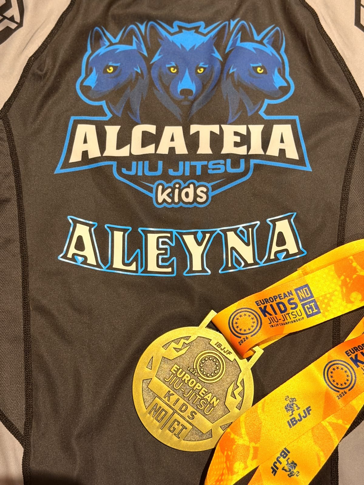 Aleyna's Alcateia rashguard with her name and the bronze medal from the European Kids No-Gi IBJJF Championship 2026.