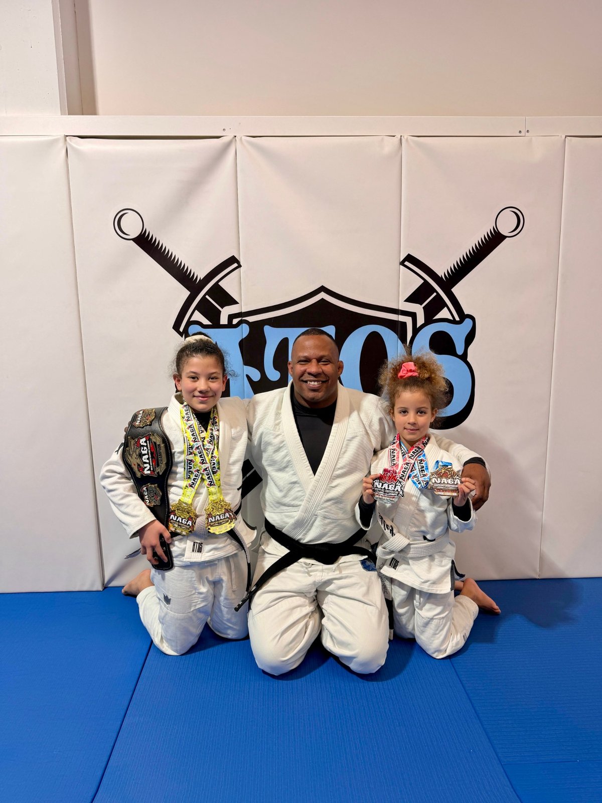 Aleyna and her sister in gi with their NAGA Paris medals, March 2026.