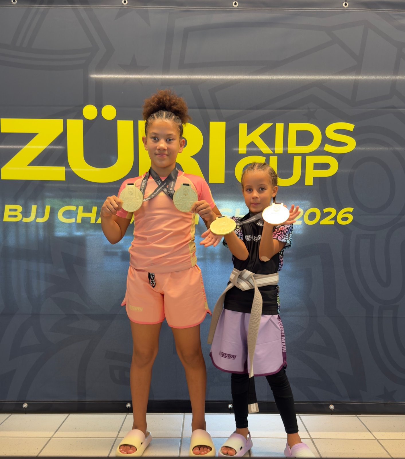Aleyna and her sister showing their medals from the Züri Kids Cup BJJ Championship 2026.